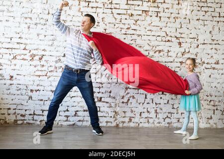 Glücklicher Vater in Superhelden-Kostüm und seine Tochter Stockfoto