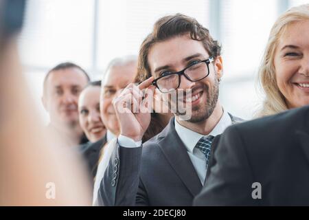 Nahaufnahme. Lächelnder Geschäftsmann steht in einer Reihe mit seinen Kollegen Stockfoto