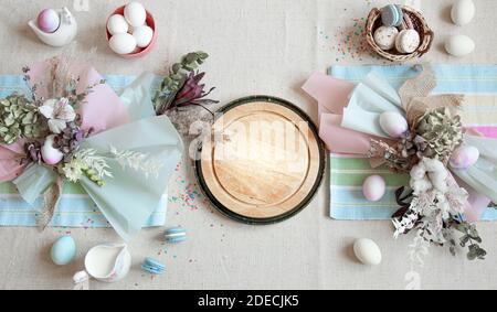 Osterkomposition mit Blumen, Eiern und Holzfläche für Text in Pastellfarben flach legen. Stockfoto