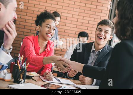Lächelnd glücklich schwarze Geschäftsfrau schüttelt Hände mit Partner im Büro Meeting-Angebot Glückwünsche zum erfolgreichen Geschäftsabschluss Stockfoto