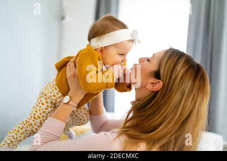 Glückliche liebevolle Familie. Mutter und Kind Mädchen spielen, küssen und umarmen Stockfoto
