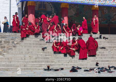 Xiahe, Provinz Gansu / China - 28. April 2017: Tibetische Mönche der Gelug-Schule an der Treppe eines Gebäudes im Labrang-Kloster. Informell zu mir Stockfoto