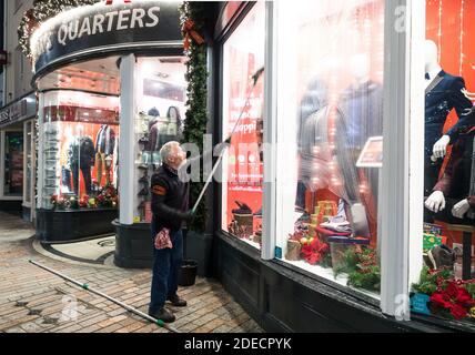 Cork City, Cork, Irland. November 2020. Rory O’Donovan aus Kileens putzt die Fenster des Herrenladens Gentleman’s Quarters in Patrick’s Street, Cork, in Vorbereitung auf die Wiedereröffnung der Geschäfte am 1. Dezember, wenn das Land eine sechswöchige Stufe 5-Sperre beendet. - Credit; David Creedon / Alamy Live News Stockfoto