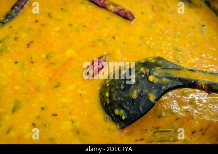 Nahaufnahme von Dal (Linsen) Curry mit roten Chilis und A Schwarze Schöpfkelle in sie eingetaucht Stockfoto