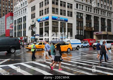 NEW YORK, USA - 1. JULI 2013: Fußgänger überqueren die 7th Avenue in New York. Fast 19 Millionen Menschen leben in der Metropolregion von New York City. Stockfoto