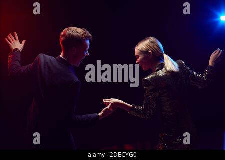 Seitenansicht Umriss eines glücklichen jungen Paares, das zusammen tanzt, während Genießen Party bei Abschlussball Nacht vor schwarzem Hintergrund Stockfoto