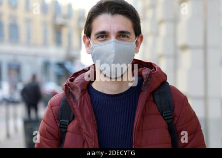 Porträt des jungen Mannes in Gesichtsmaske steht auf der Straße Und Blick auf die Kamera Stockfoto