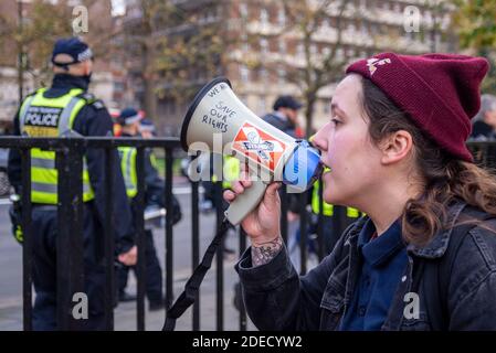 Junge weiße kaukasische Frau, die durch ein Megaphon bei einem Anti-Lockdown-Protest in London, Großbritannien, die Polizei ansingt. Steh auf, rette unsere Rechte Stockfoto