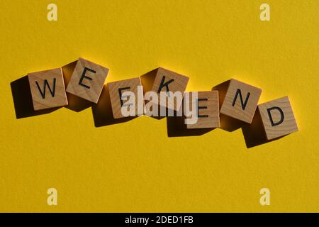 Wochenende, Wort in Holzbuchstaben isoliert auf hellgelben Hintergrund Stockfoto