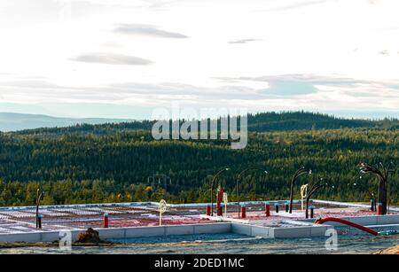 Hausfundament in Beton mit Leitungen und Leitungsverbindungen ragen heraus, fertig für Wände. Überwachung eines wilden Waldtales. . Hochwertige Fotos Stockfoto