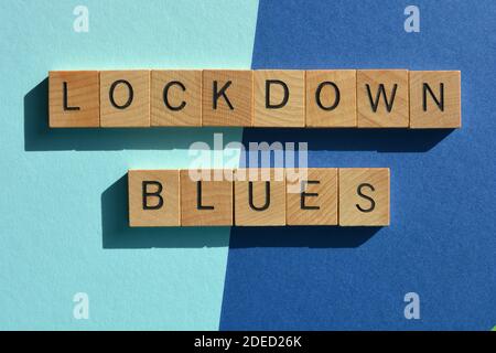 Lockdown Blues, Wörter in Holzalphabet Buchstaben isoliert auf blauem Hintergrund. Stockfoto