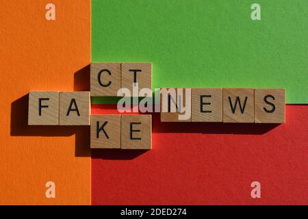 Fact, Fake, Nachrichten, Wörter in Holz-Alphabet Buchstaben auf rot, orange und grün Hintergrund. Stockfoto