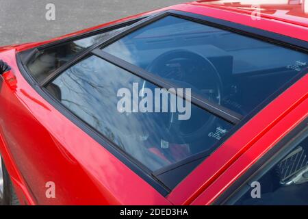 Nahaufnahme Detail der rechten Seitentür eines roten Lamborghini Countach 25th Anniversary Edition, das Lenkrad durch das Fenster sichtbar Stockfoto