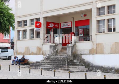 NAZARE, PORTUGAL - 22. MAI 2018: Vor CTT Correios de Portugal (nationaler Postdienst) und Banco CTT (Banken- und Finanzdienstleistung) sitzen Menschen Stockfoto
