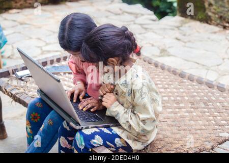 Indische Schule Kinder Mädchen beobachten Online-Bildung Klassen zu Hause. COVID-19 Pandemie zwingt Kinder online zu lernen. Stockfoto