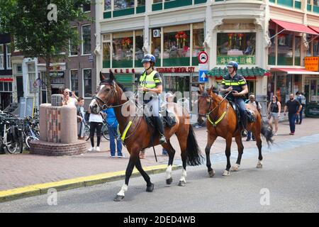 AMSTERDAM, NIEDERLANDE - 10 JULI 2017: Pferdesport Polizisten patrouillieren, Amsterdam. Polizei (politie) beschäftigt mehr als 63.000 Menschen in der Netherlan Stockfoto