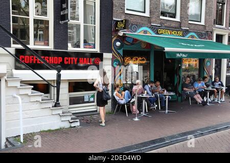 AMSTERDAM, NIEDERLANDE - 10. JULI 2017: Menschen besuchen Cafés in Amsterdam, Niederlande. Coffeeshops verkaufen legal Marihuana für persönlichen Konsum Stockfoto