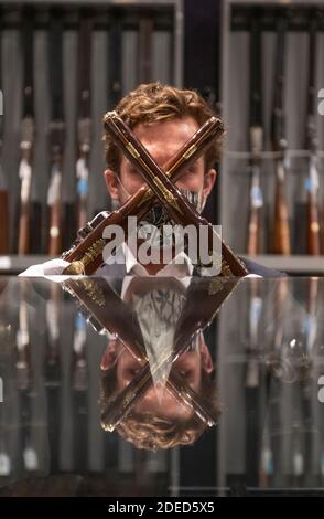 Knightsbridge, London, Großbritannien. November 2020. Vorschau von Bonhams' Antique Arms, Modern Sporting Guns & Exceptional Firearms Verkauf in London. Der Verkauf findet am 3. Dezember statt. Bild: Bonhams Mitarbeiter mit einem außergewöhnlichen Paar 'Flintlock' Repeating Air Pistols aus Blair Castle, Schottland von Edward Bate, London, um 1770, Schätzung £20,000-30,000. Quelle: Malcolm Park/Alamy Live News Stockfoto