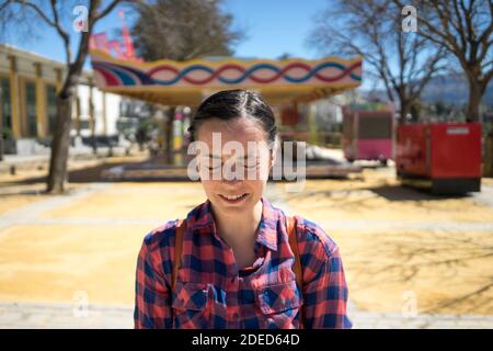 Frau in einem Vergnügungspark macht lustige Gesichter Stockfoto