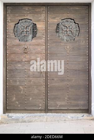 Alte braune doppelte Holztür mit Metall und Glas verziert