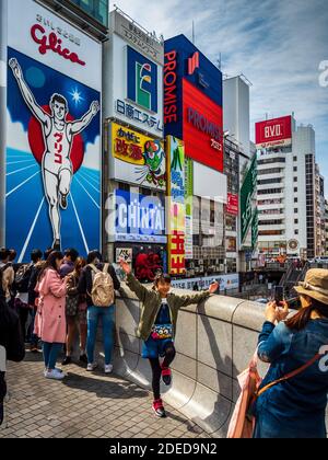 Dotonbori Glico Running man Sign Osaka Japan - Touristen fotografieren unter dem berühmten Glico Running man Schild im Zentrum von Osaka. Stockfoto