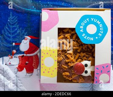 Rudolph der Rotnasen-Donut in der frischen Kiste aus der Bäckerei Bei Marks & Spencer setzen wir auf Serviette Serviette Stockfoto
