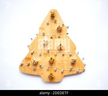 Schöner Weihnachtsbaum aus Holz mit Girlande und Ornamenten auf weißem Hintergrund. Stockfoto