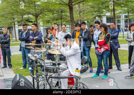 Ein White Suit Schlagzeuger einer Shenzhen lokalen Street Band, die im Central Park von Shenhzhen, Guangdong, China auftrat Stockfoto