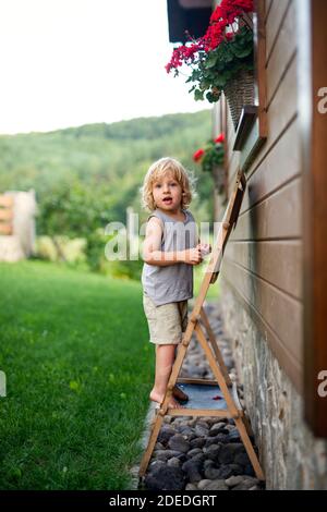 Happy kleine blonde junge spielen im Sommer im Freien von Haus. Stockfoto