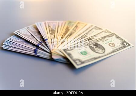 Haufen Geld Fan auf einem grauen Hintergrund. Amerikanische Dollar-Scheine von verschiedenen Stückelungen verteilt in einem fanned Stockfoto