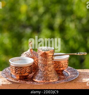 Traditioneller schwarzer bosnischer Kaffee in schöner Kupferkeuze am Holztisch Stockfoto