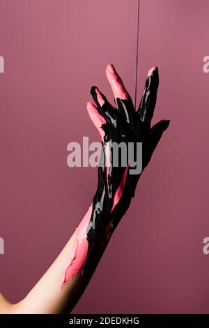 Teilansicht der Hand mit tropfender Farbe isoliert auf rosa Stockfoto