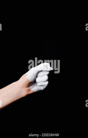 Teilansicht der weiß gemalten Faust isoliert auf schwarz Stockfoto