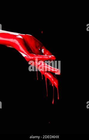 Teilansicht der bemalten Hand mit roter tropfender Farbe isoliert Auf Schwarz Stockfoto