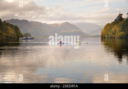 Freizeitbeschäftigung im englischen Lake District zwei Kanufahrer entspannen sich in den frühen Morgenreflexionen auf Derwent Water bei Keswick, Cumbria. Stockfoto