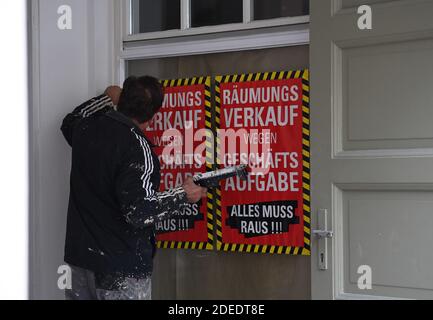Potsdam, Deutschland. November 2020. Ein Handwerker malt ein Geschäft mit einem Schild mit der Aufschrift 'Verkaufsverkauf wegen Schließung'. Quelle: Britta Pedersen/dpa-Zentralbild/dpa/Alamy Live News Stockfoto