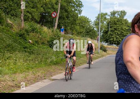 Triatlon Tür brügge, Radfahren zweiten Teil, Radfahrer, Männer unterstützende Frau, Frauen unterstützende Männer, Menschen unterstützen einander, Wettbewerb schnellen Sport Stockfoto