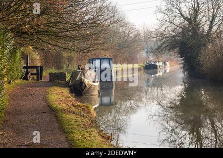 Kanalboote vertäuten im Spätherbst am Kennet und Avon Kanal an einem sonnigen nebligen Wintermorgen, Bradford on Avon, Wiltshire, Großbritannien Stockfoto