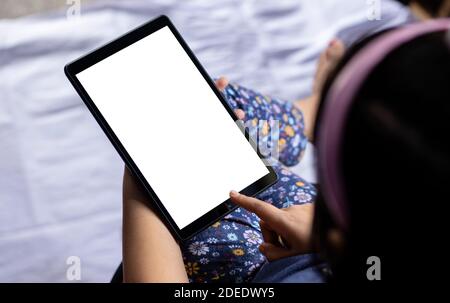 Ein indisches Mädchen Kind hält Tablet mit weißem leeren Bildschirm In der Hand Stockfoto
