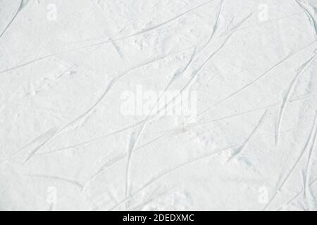 Ice Rink Textur mit Spuren von Eislaufen. Selektiver Fokus der Skate-Markierungen auf dem Eis. Stockfoto