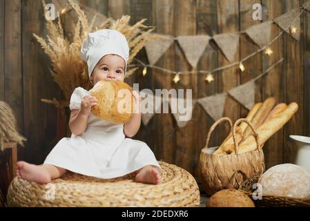 Kleine süße Mädchen Bäcker essen frisches Brot Stockfoto