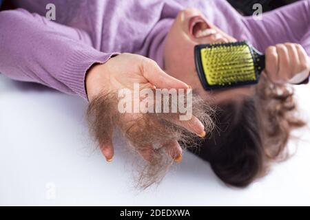 Junges Mädchen Angst vor ihrem Haarausfall, auf einem weißen Hintergrund. Stockfoto