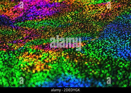 Bunt glänzend flackernden abstrakten Hintergrund. Grüne, blaue, orange, violette Bokeh-Lichter. Festlicher Hintergrund oder Struktur Stockfoto