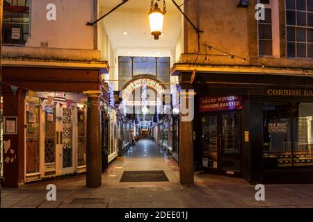 Die historische Einkaufspassage im Korridor, die in der Abenddämmerung mit Weihnachtslichtern in Bath beleuchtet wird. Bath City Centre, Somerset, England, Großbritannien Stockfoto