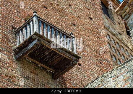 Außenansicht des Schlosses von Serralunga mit Holzbalkon und Ziegelhäusern - Stadt Serralunga, Italien, Piemont Stockfoto