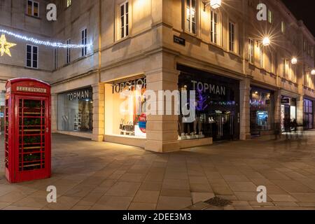 Topman & Topshop Store im Southgate Shopping Centre neben einer britischen roten Telefondose in der Abenddämmerung, Bath, England, Großbritannien Stockfoto