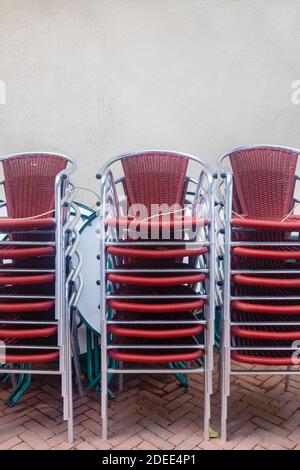 Reihen von stapelbaren holländischen Pub-Terrassenstühlen vor einer weißen Wand in der Stadt Kampen, Niederlande Stockfoto