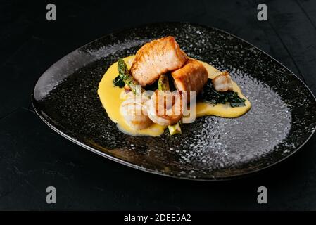 Gegrillter Lachs und Garnelen auf schwarzem Hintergrund Stockfoto