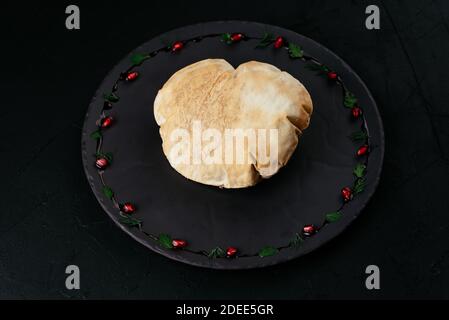 Georgischer Gemüsesalat in Tortilla-Brot auf schwarzem Hintergrund Stockfoto