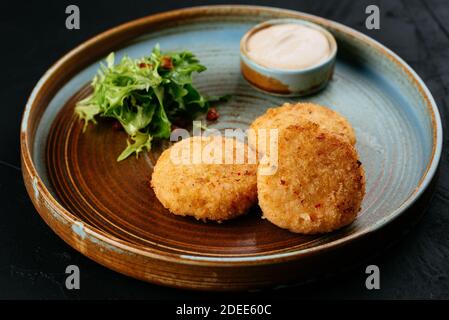 Gegrillte Lachsschnitzel mit Sauce auf schwarzem Hintergrund Stockfoto